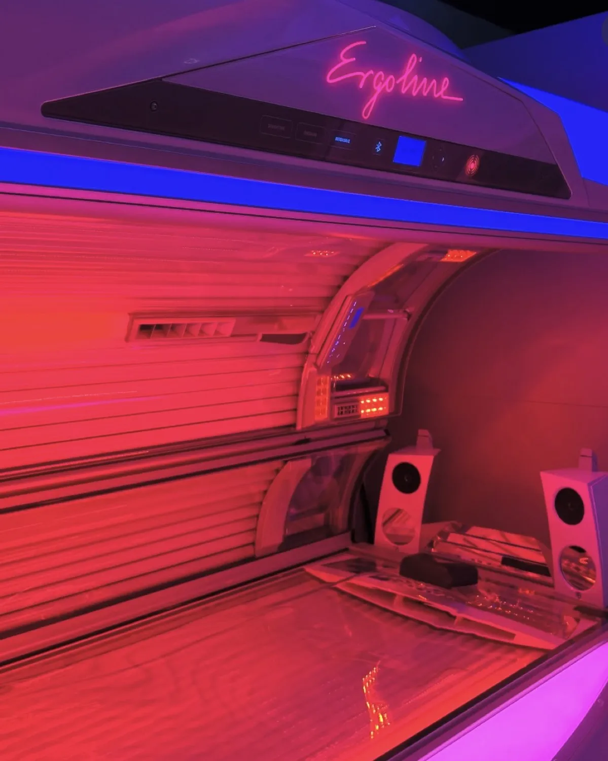 Ergoline sunbed lit in red at Equinox Tanning Studio