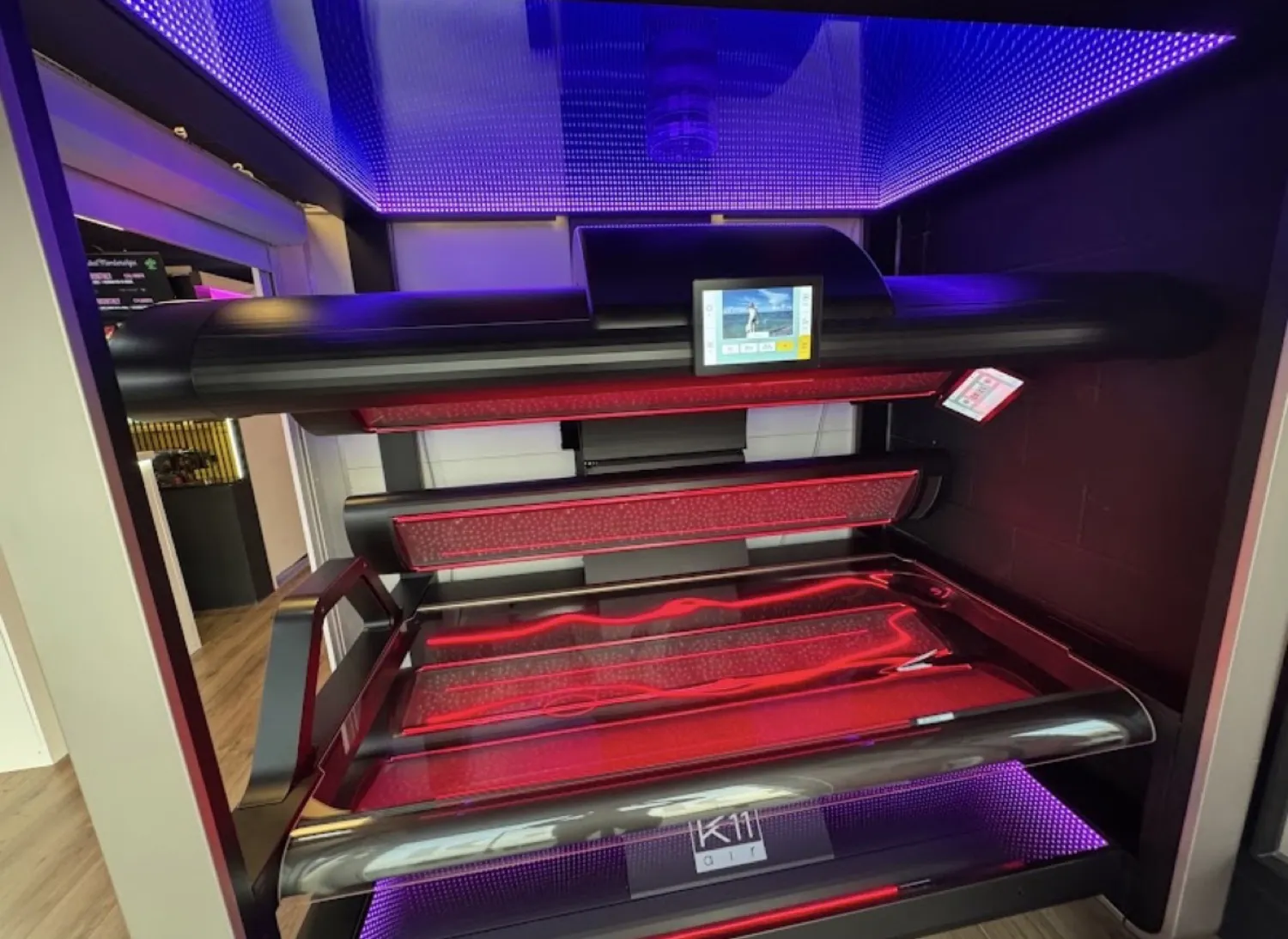 Lay down sunbed lit in red at Luxe Glow Studio